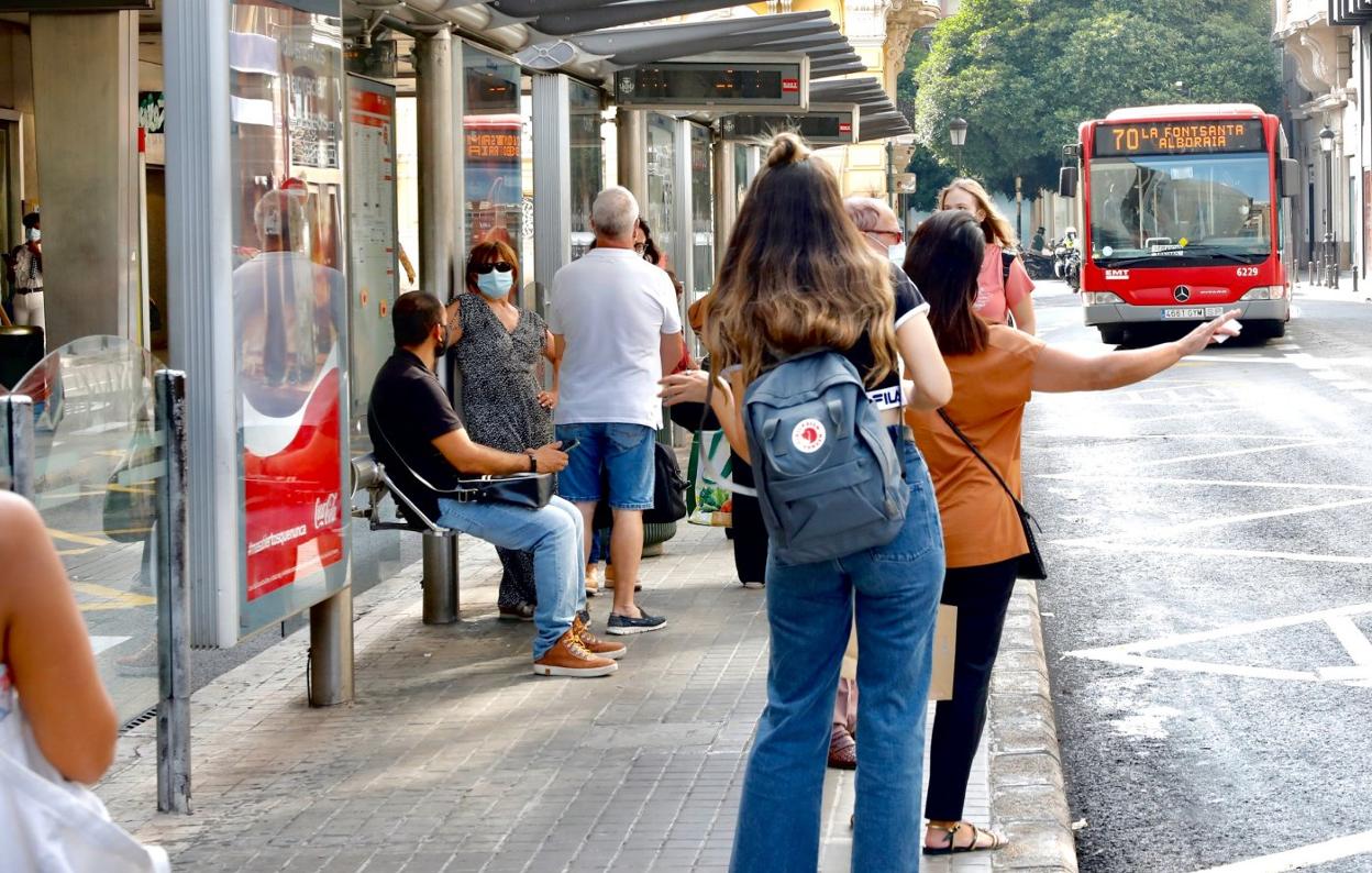 Una parada de autobús en el centro llena de usuarios. irene marsilla