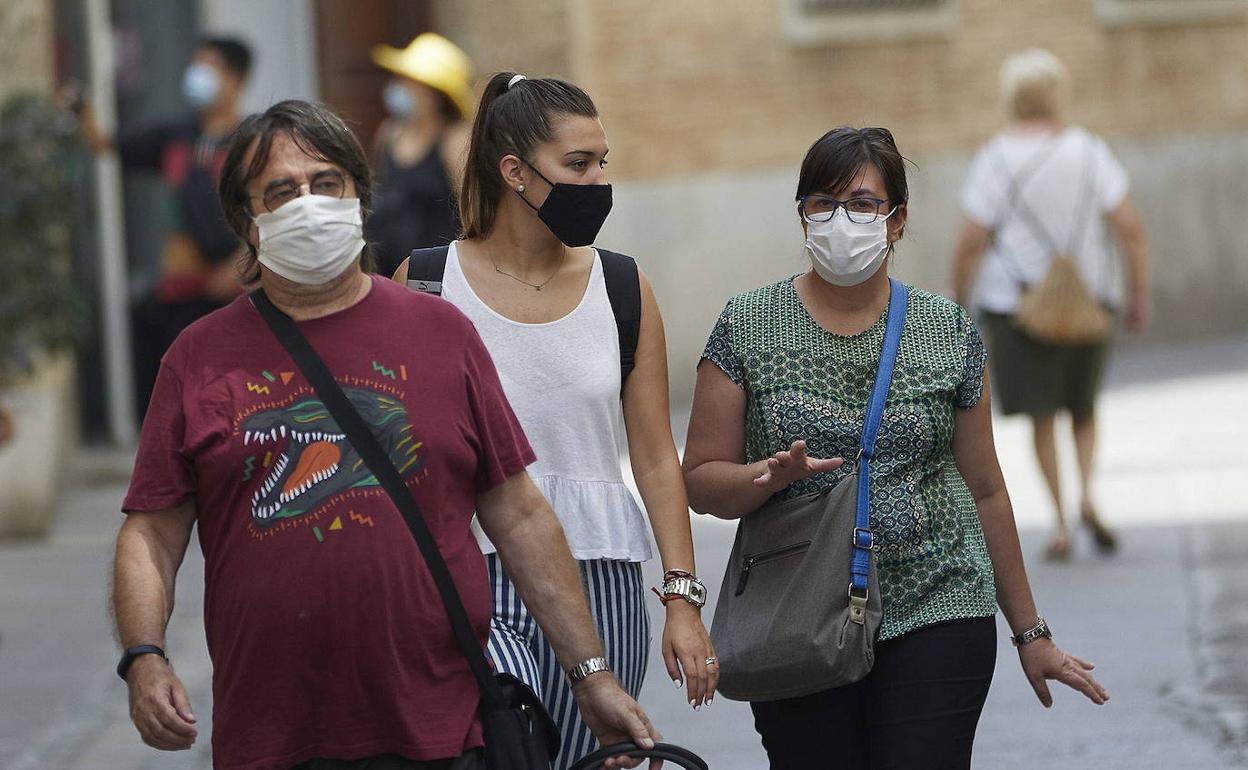 Ciudadanos andando con mascarilla por Valencia.