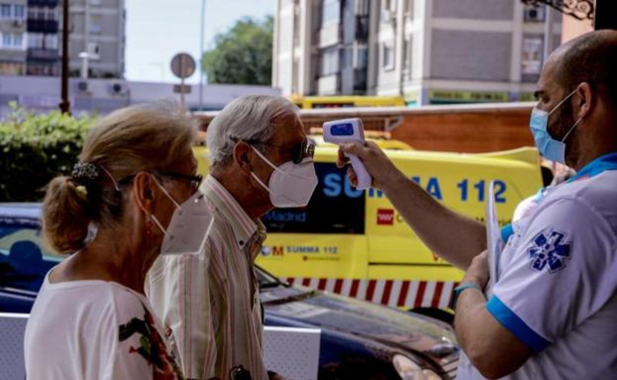 Un sanitario toma la temperatura a un hombre.