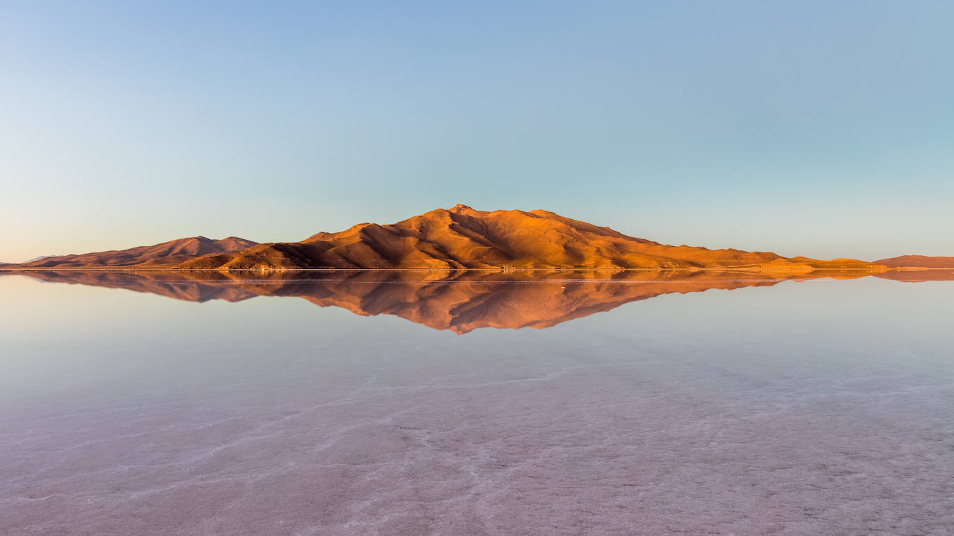 Salar de Uyumi (Bolivia) | Su impresionante panorama enamora a la vista. Más de 10.500 kilómetros cuadrados configuran el desierto de sal más grande del mundo, con un cielo azul que destaca entre su agrietado y blanco suelo y que lo convierte en uno de los rincones más únicos del planeta. 