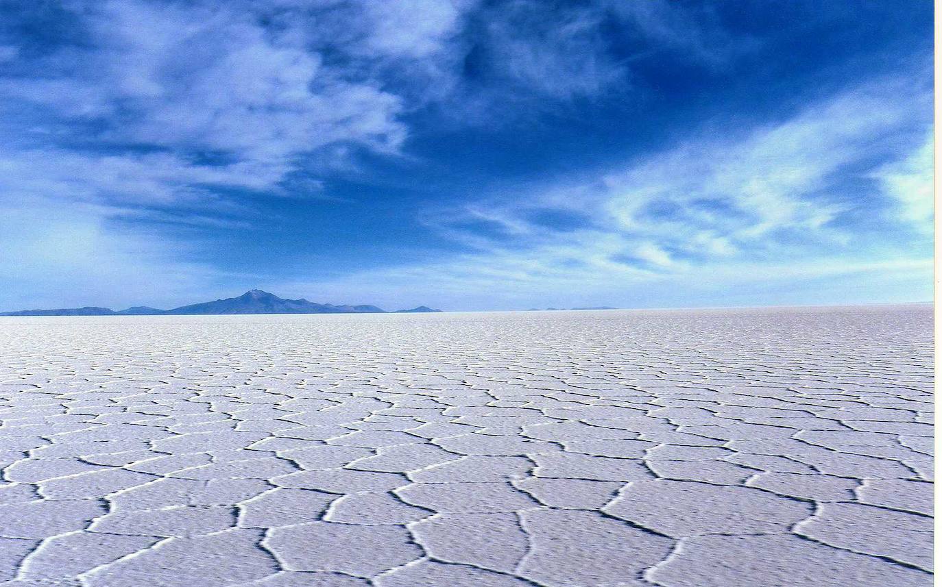 Salar de Uyumi (Bolivia) | Su impresionante panorama enamora a la vista. Más de 10.500 kilómetros cuadrados configuran el desierto de sal más grande del mundo, con un cielo azul que destaca entre su agrietado y blanco suelo y que lo convierte en uno de los rincones más únicos del planeta. 