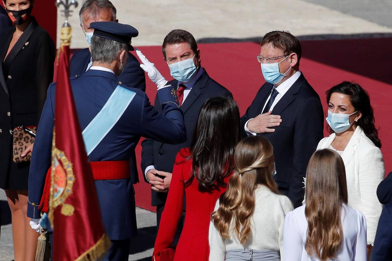 El acto del Día de la Fiesta Nacional, presidido por los reyes, se celebra en la plaza de la Armería del Palacio Real de Madrid. Felipe VI, la reina Letizia, la princesa Leonor y la infanta Sofía han sido recibidos por el presidente del Gobierno, Pedro Sánchez. En la plaza se encontraban todos los integrantes del Ejecutivo, salvo la titular de Exteriores, Arancha González Laya, incluido el vicepresidente segundo, Pablo Iglesias (que nunca había acudido a esta celebración) y el resto de ministros de Podemos. No ha faltado el presidente de la Comunitat, Ximo Puig, ni la de la Comunidad de Madrid, Isabel Díaz Ayuso