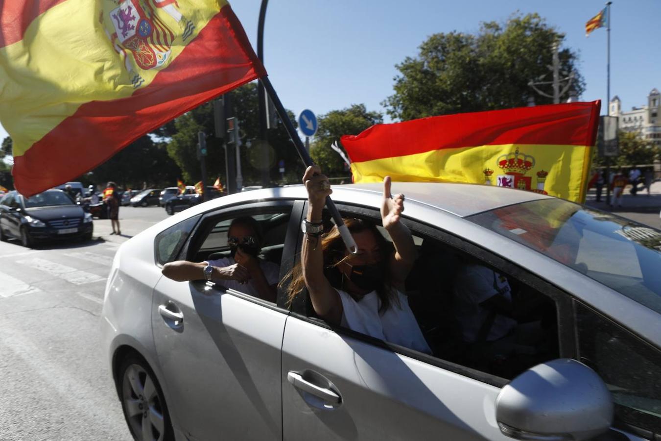 Decenas de coches han recorrido este lunes, Día de la Fiesta Nacional, las principales calles de Valencia con banderas de España. Representantes de Vox han realizado una ofrenda floral a la bandera española en el paseo de la Alameda y han iniciado a continuación un recorrido con coches y motos por diferentes barrios de la ciudad para defender los derechos de los ciudadanos y criticar los confinamientos por el Covid al considerarlos un estado de excepción encubierto. 