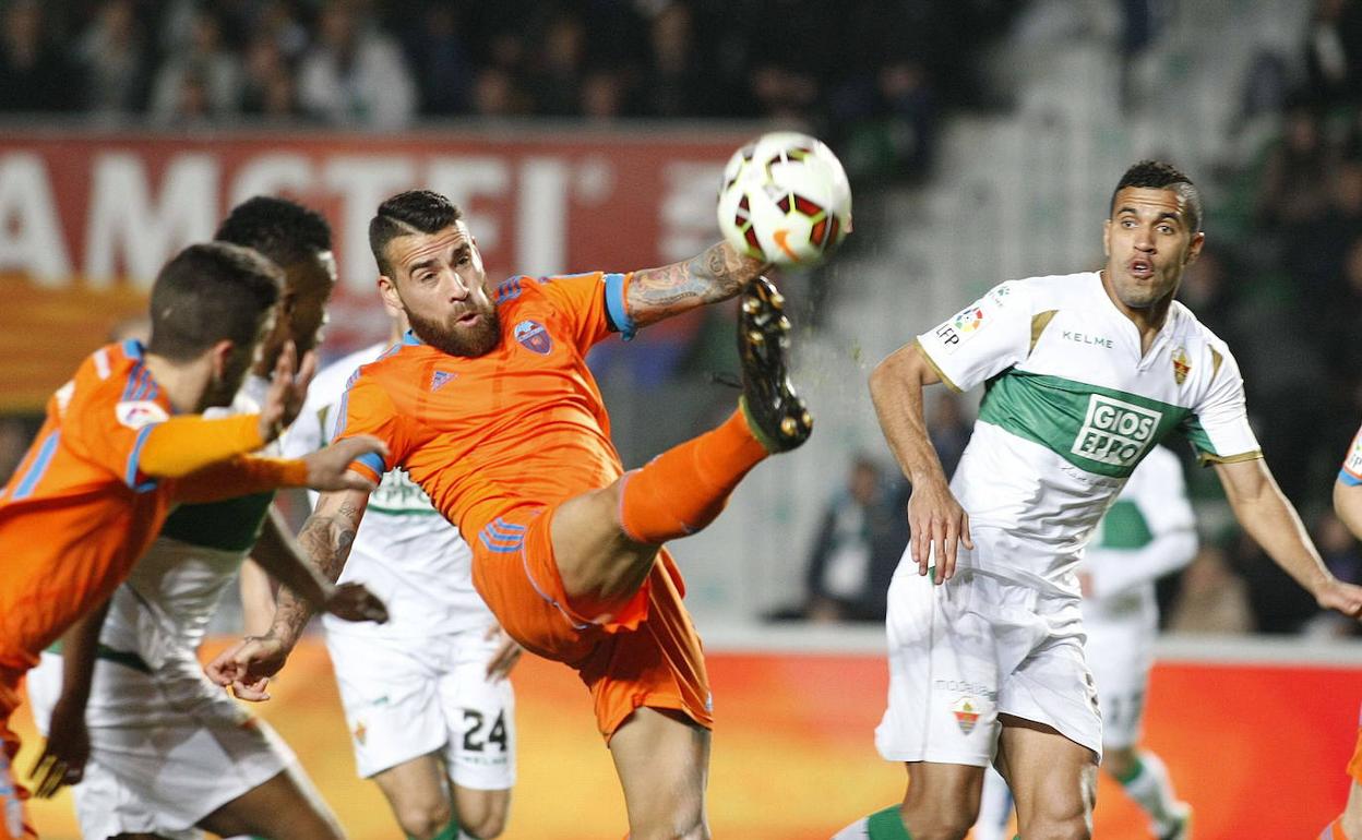 Otamendi, en un partido en el Martínez Valero, controla el balón ante Cristian y Mendes. 