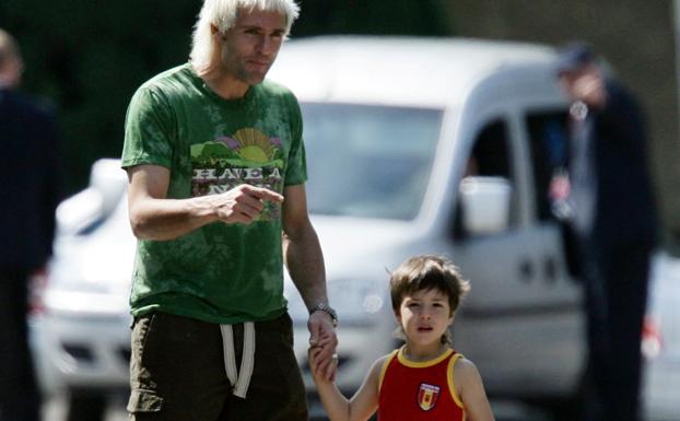 Santi Cañizares camina de la mano junto a su hijo Lucas. 