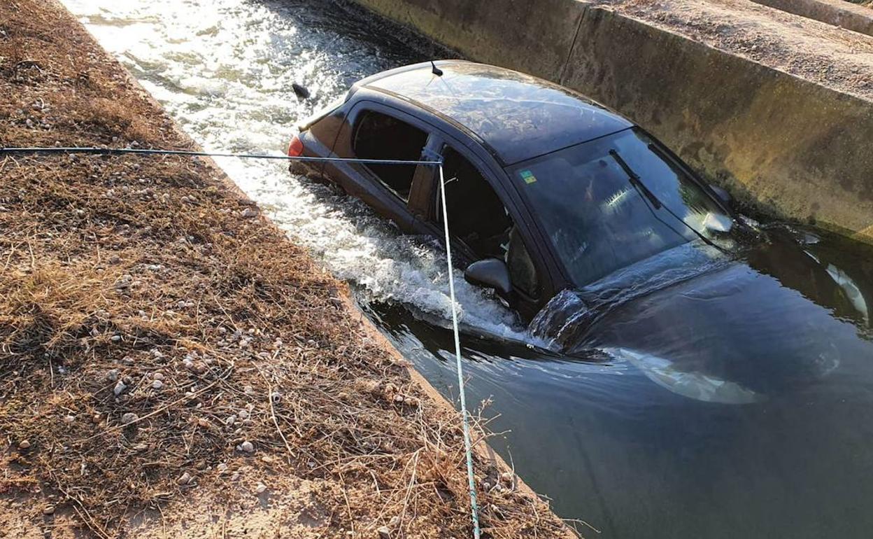 Bomberos sacan el coche de la acequia