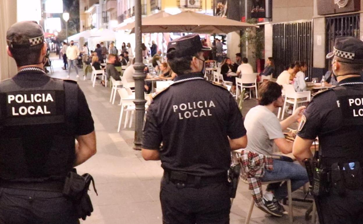 Varios agentes vigilan una de la calles peatonales de Alicante para que se cumplan las medidas sanitarias. 