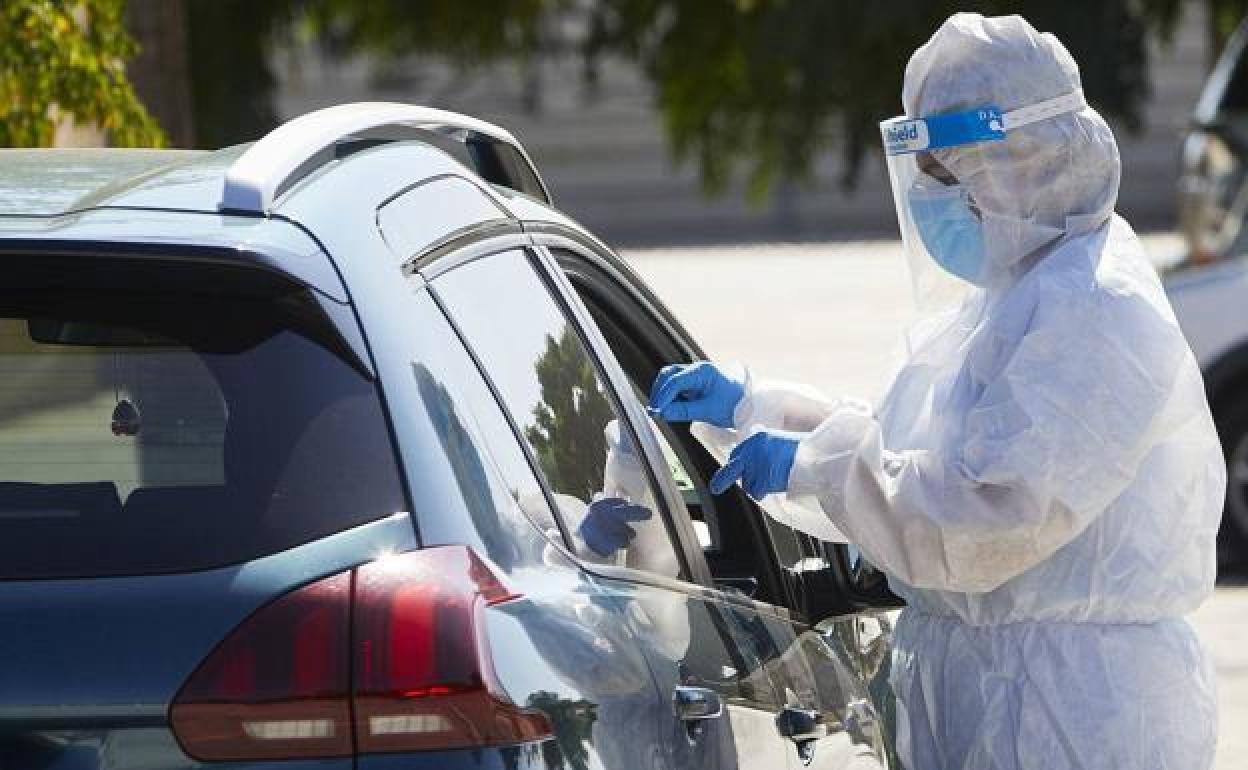 Un sanitario realiza pruebas PCR a las puertas del hospital La Fe. 