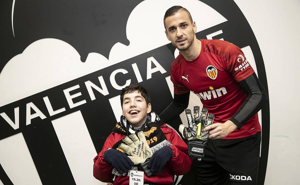 Jaume Doménech posa con Cristóbal, que recibe unos guantes firmados por uno de los capitanes. 