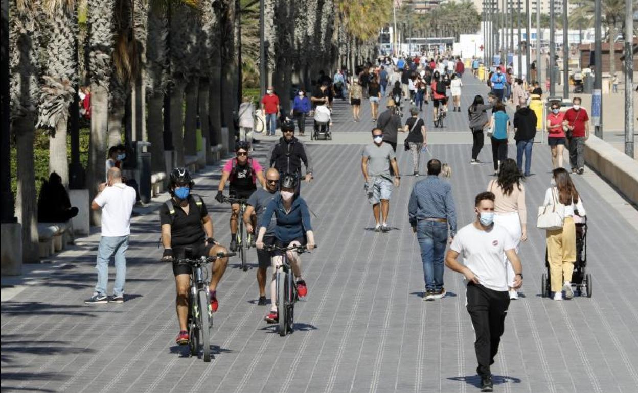 Los viandantes pasean con mascarilla por Valencia.