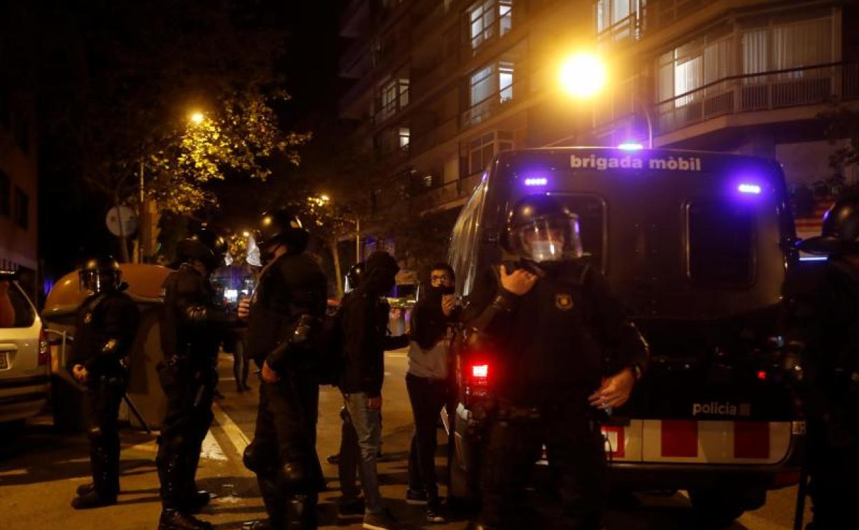 Mossos d'Esquadra retienen a una de las doscientas personas queparticipan este miércoles en una protesta frente al cuartel de la Guardia Civil donde se encontraba uno de los detenidos. 