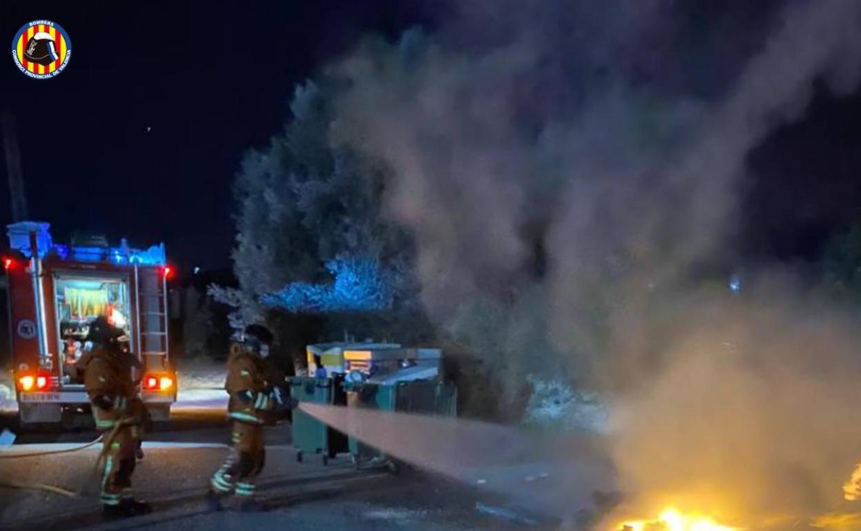 Los bomberos extinguen el fuego declarado el sábado por la noche en un contenedore en Moixent. 