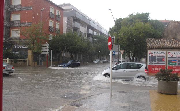 Varios coches circulan por las calles inundadas de Dénia.