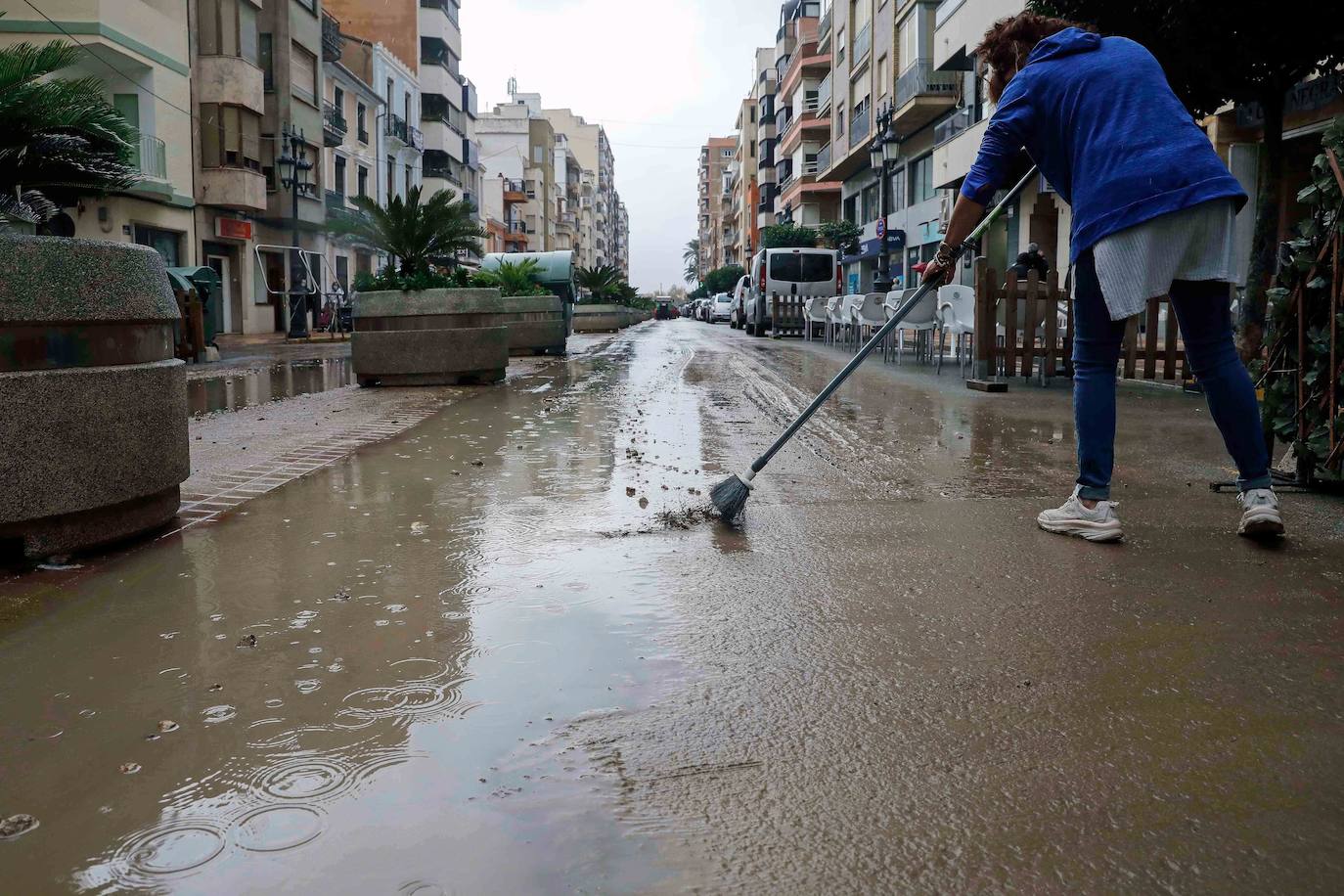 Una vecina retira agua de la calle en Cullera, donde han caído mas de 100 litros