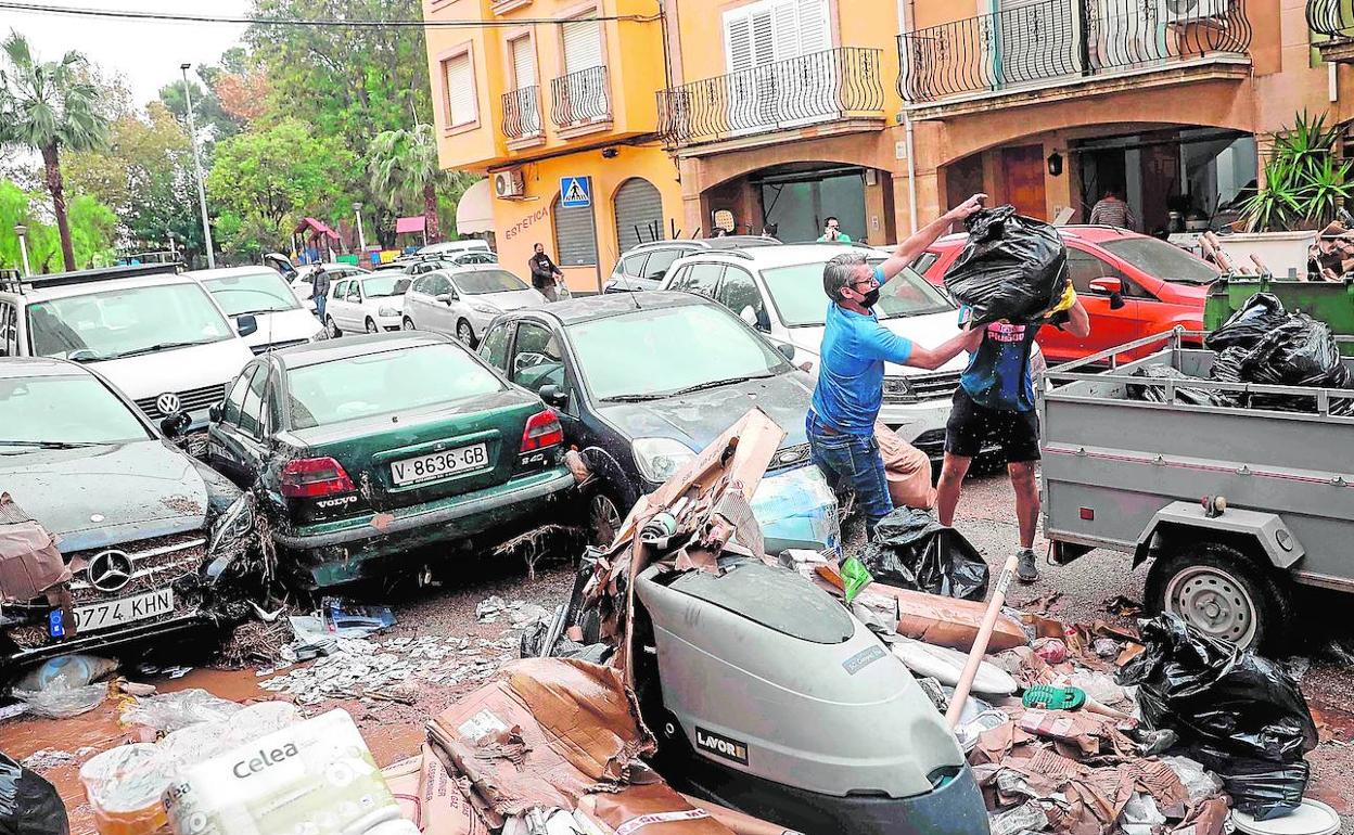 Vecinos de Benifaió retiran los escombros causados por el temporal. 