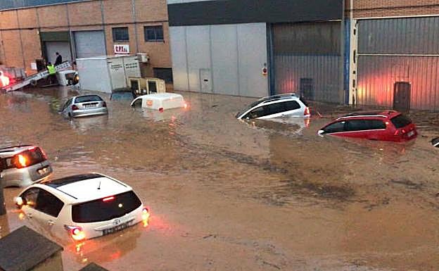 Galería. Los coches casi cubiertos por el agua y la grúa con Bernabé encima al fondo. 