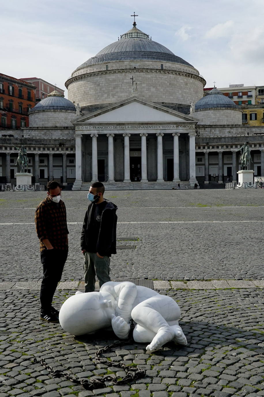 Una escultura en mármol blanco, que representa a un niño acurrucado y con una muñeca encadenada, ha sido abandonada en el centro de la plaza Plebiscito, en Nápoles. 