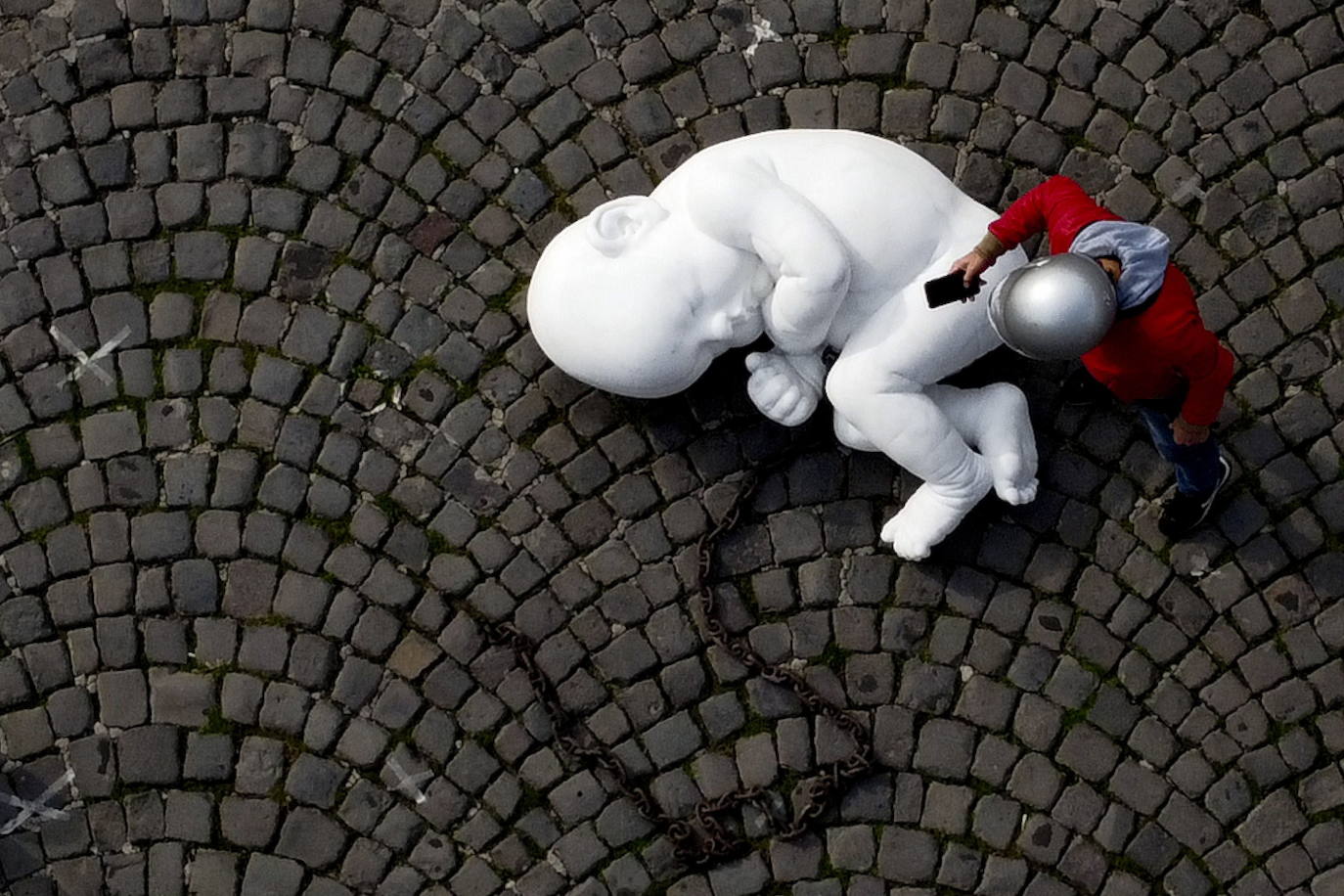 Una escultura en mármol blanco, que representa a un niño acurrucado y con una muñeca encadenada, ha sido abandonada en el centro de la plaza Plebiscito, en Nápoles. 