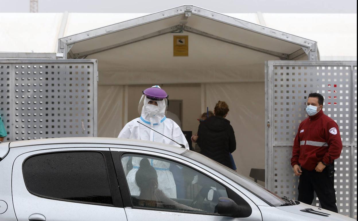 Una sanitaria realiza PCR al lado del hospital de campaña