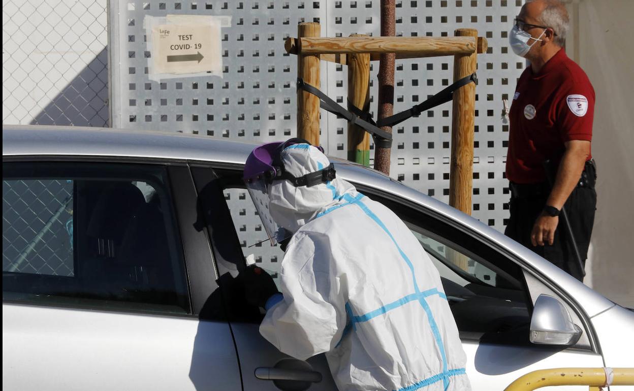 Un sanitario realiza una PCR a las puertas de La Fe de Valencia.