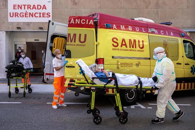 Sanitarios trasladan a un paciente de una ambulancia a Urgencias del hospital Clínico de Valencia. 