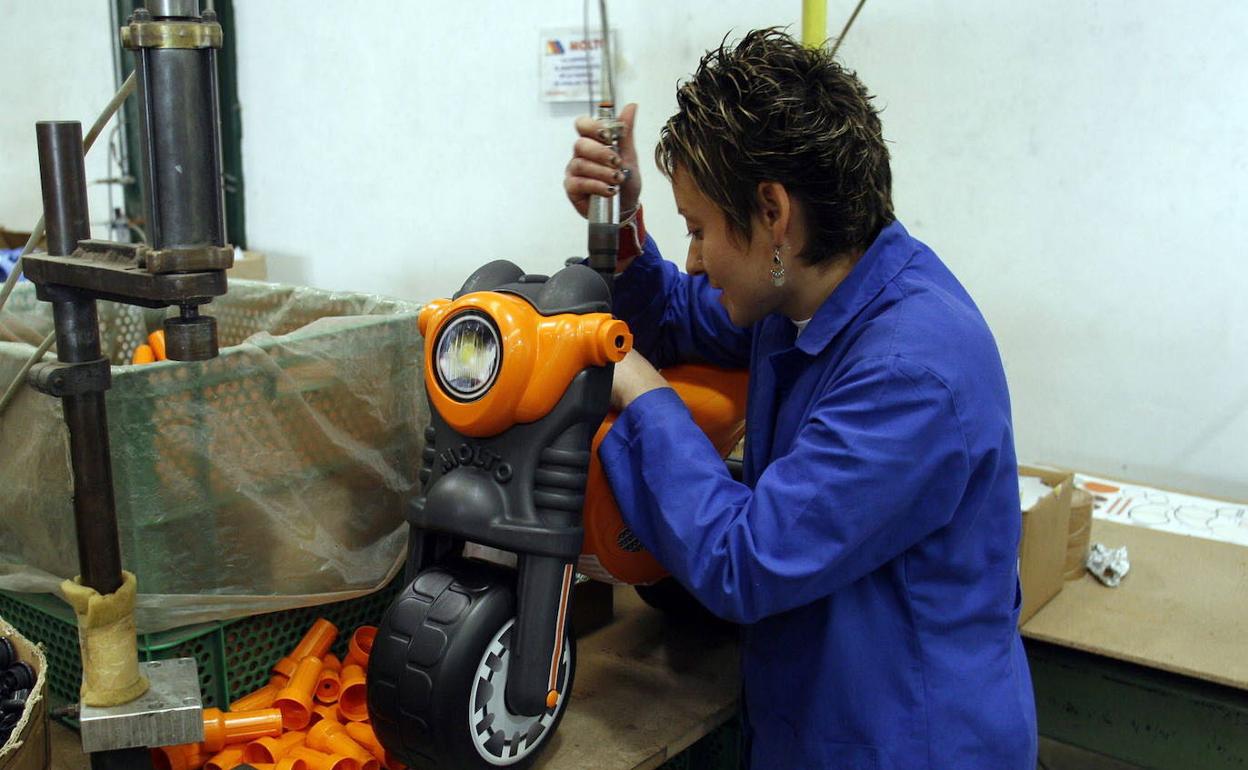 Una empleada trabaja en la cadena de fabricación de un juguete en una empresa de Ibi. 