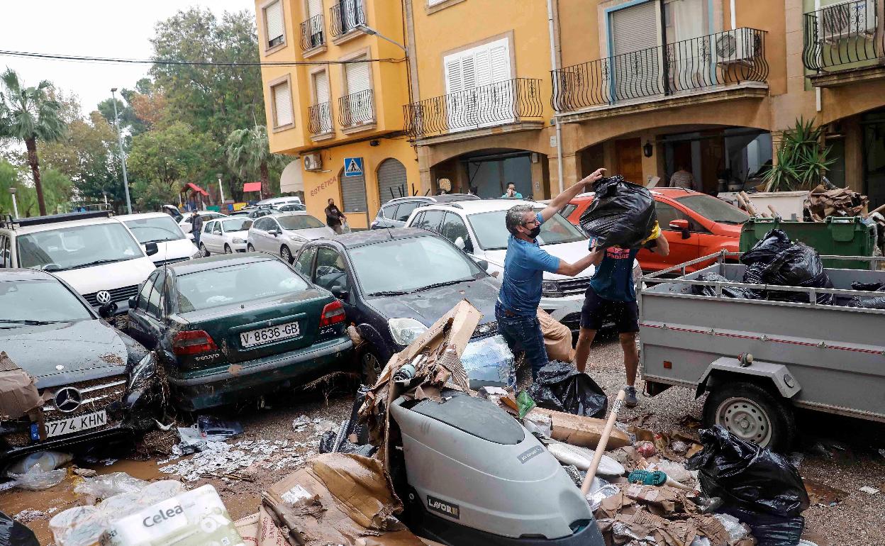 Vecinos de Benifaió limpian tras el temporal. 