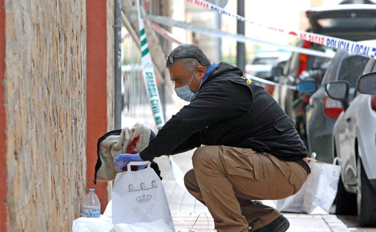 Un agente de la unidad de criminalística recoge ropa de la joven agredida. 