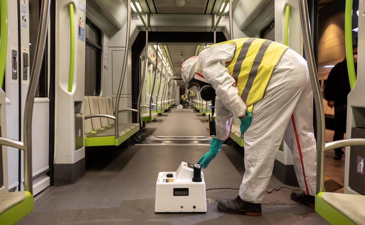 Un técnico de Ferrocarriles de la Generalitat realiza labores de desinfección  en un vagón. 