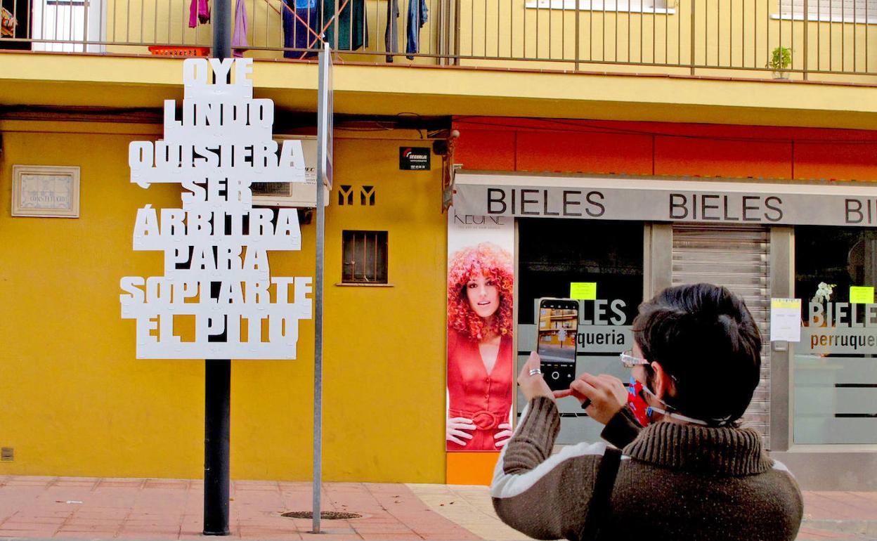 Una vecina fotografía uno de los carteles colocados por el Ayuntamiento de El Verger. 