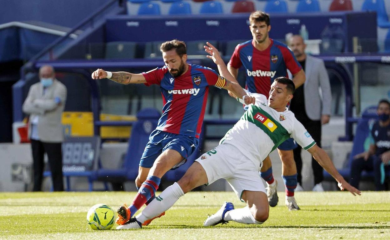 Morales disputa un balón con Diego González. 