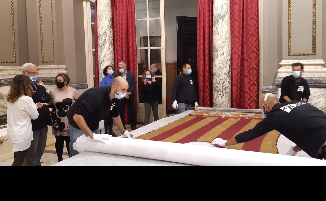 Proceso de embalaje de la Real Senyera de 1928 para trasladarla a Ivacor, donde se someterá a una restauración. 