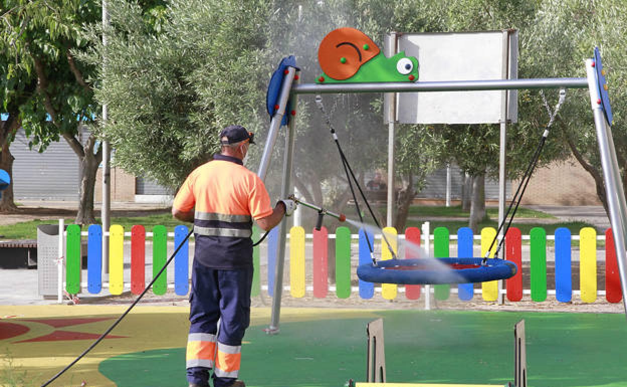 Un trabajador desinfecta un parque infantil en Puçol. 