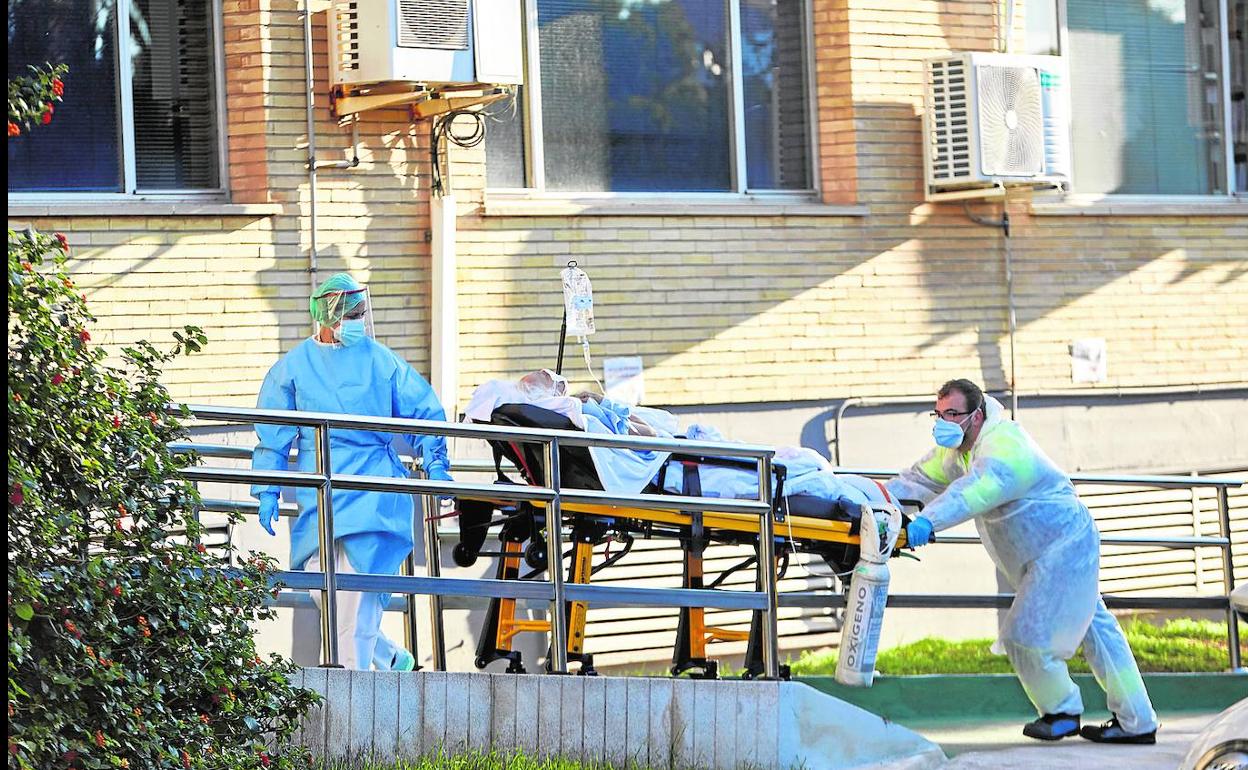 Dos sanitarios trasladan a un enfermo al interior del pabellón habilitado en la antigua Fe.