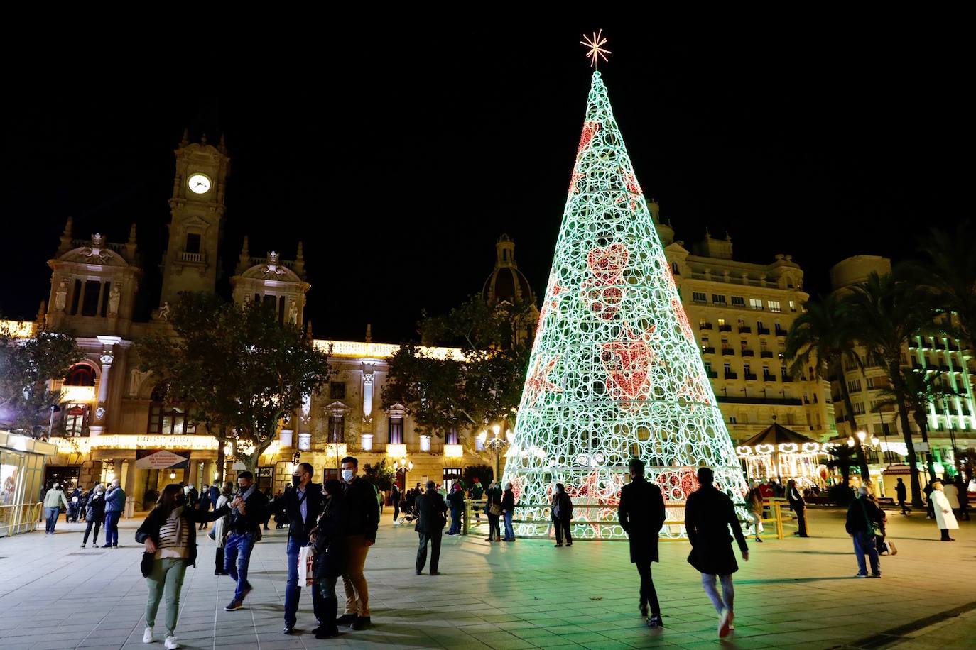 El alcalde Ribó ha asistido esta tarde al encendido en la plaza del Ayuntamiento, acompañado por las falleras mayores de Valencia, Consuelo Llobell y Carla García. La iluminación se estrena en la ciudad con quejas por el escaso gasto frente al aumento en otras ciudades para ayudar al comercio.