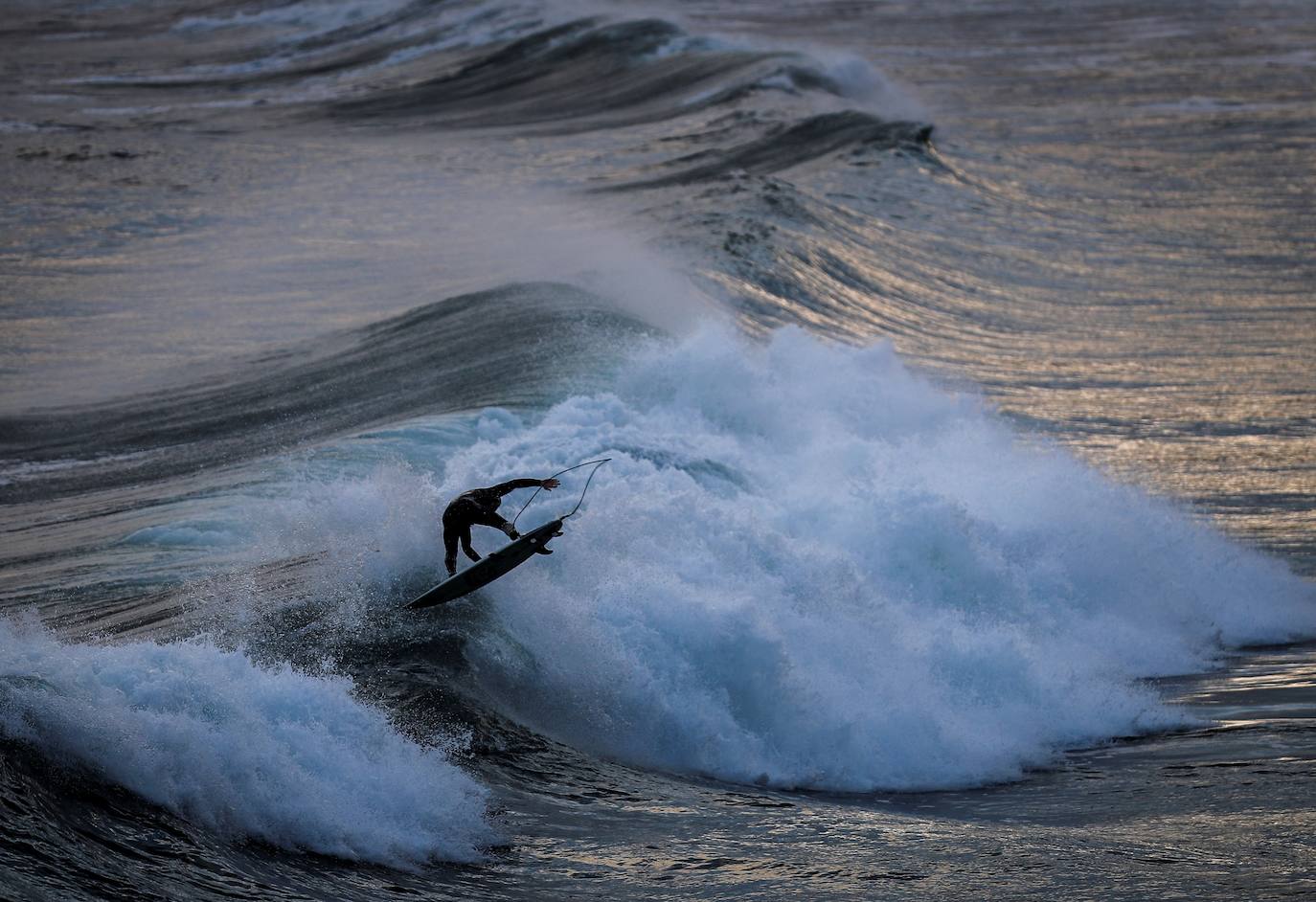 Un surfista hace una maniobra en la playa de La Concha de San Sebastián.