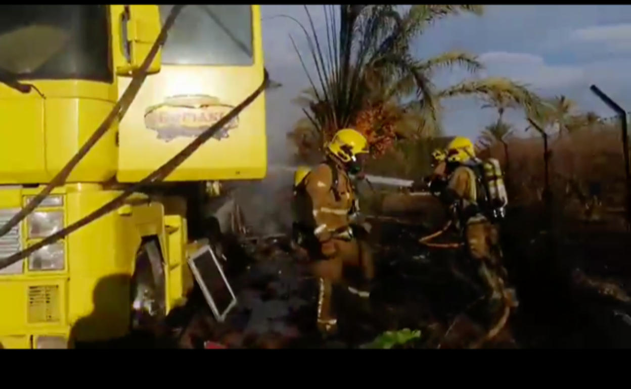 Los bomberos apagan el fuego del camión. 