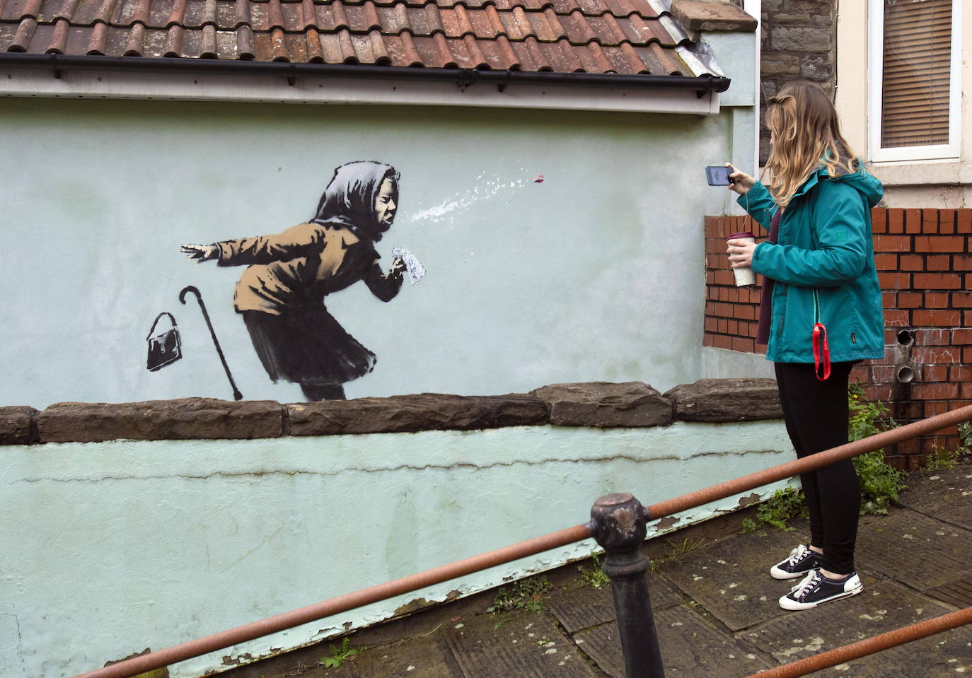 Bristol ha amanecido con una sorpresa: un nuevo mural del popular y misterioso artista urbano Banksy. La pintura titulada 'Aachoo!!' representa a una anciana estornudando, con su dentadura postiza volando, y apareció en la calle Vale Street durante la madrugada del jueves. 