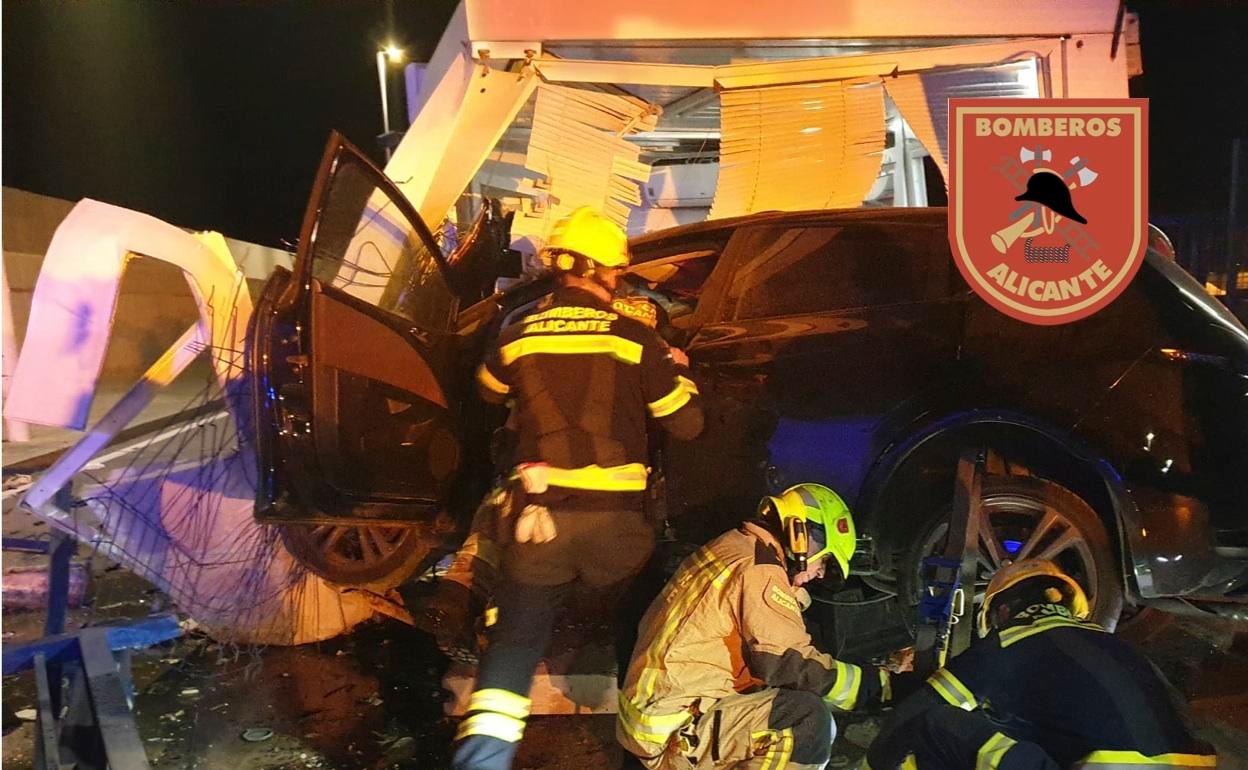 Los bomberos rescatan al conductor a través del lateral del vehículo. 