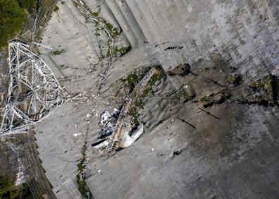 Imagen secundaria 1 - Suspendido de tres grandes torres de hormigón, el radiotelescopio se balanceó y cayó.