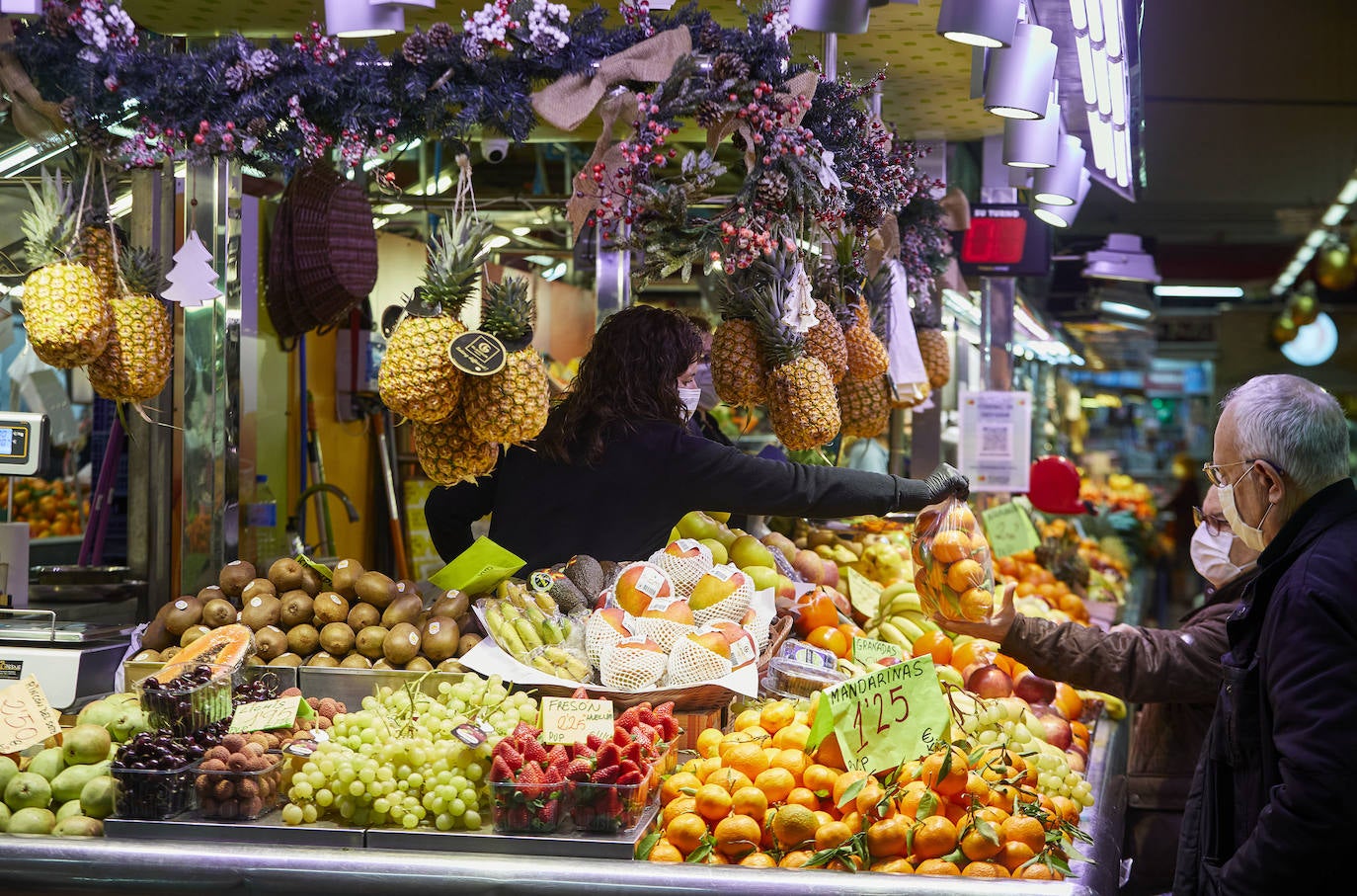 Con la Navidad a la vuelta de la esquina, los valencianos aprovechan para disfrutar del ambiente y realizar las compras en los mercados de la ciudad. La celebración de las fiestas navideñas este año será atípicas y con restricciones por la pandemia del coronavirus. En imagen, el Mercado Central de Valencia este martes.