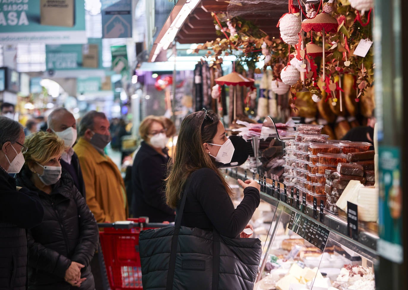 Con la Navidad a la vuelta de la esquina, los valencianos aprovechan para disfrutar del ambiente y realizar las compras en los mercados de la ciudad. La celebración de las fiestas navideñas este año será atípicas y con restricciones por la pandemia del coronavirus. En imagen, el Mercado Central de Valencia este martes.