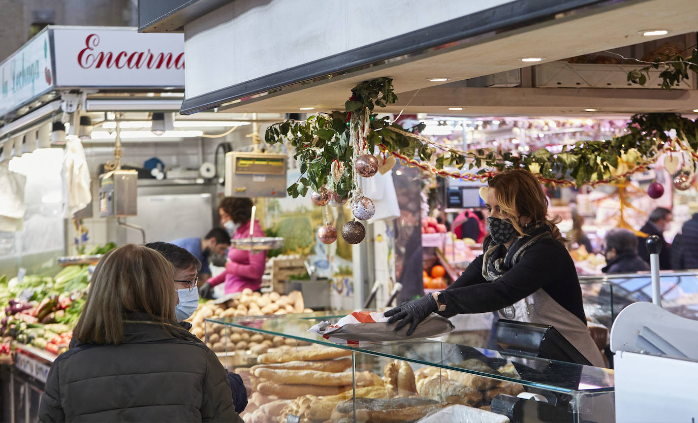 Con la Navidad a la vuelta de la esquina, los valencianos aprovechan para disfrutar del ambiente y realizar las compras en los mercados de la ciudad. La celebración de las fiestas navideñas este año será atípicas y con restricciones por la pandemia del coronavirus. En imagen, el Mercado Central de Valencia este martes.