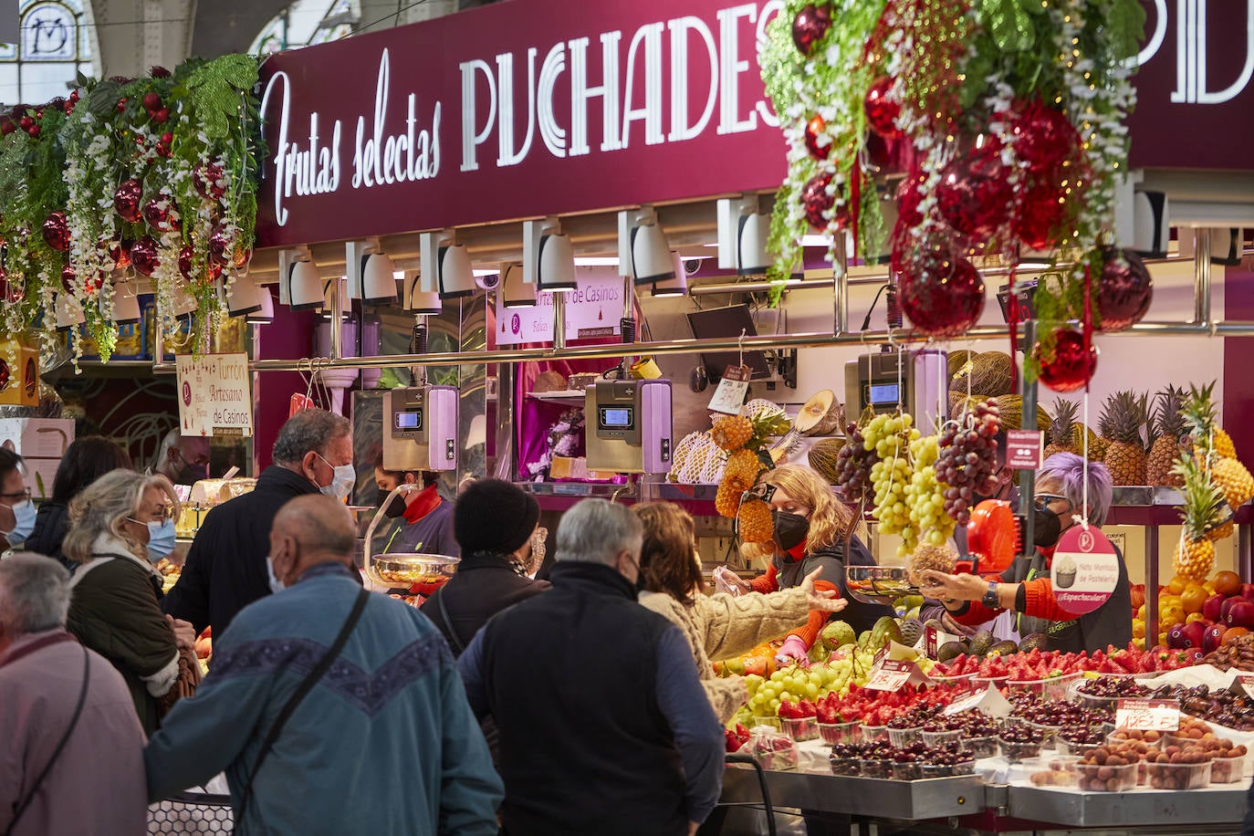 Con la Navidad a la vuelta de la esquina, los valencianos aprovechan para disfrutar del ambiente y realizar las compras en los mercados de la ciudad. La celebración de las fiestas navideñas este año será atípicas y con restricciones por la pandemia del coronavirus. En imagen, el Mercado Central de Valencia este martes.