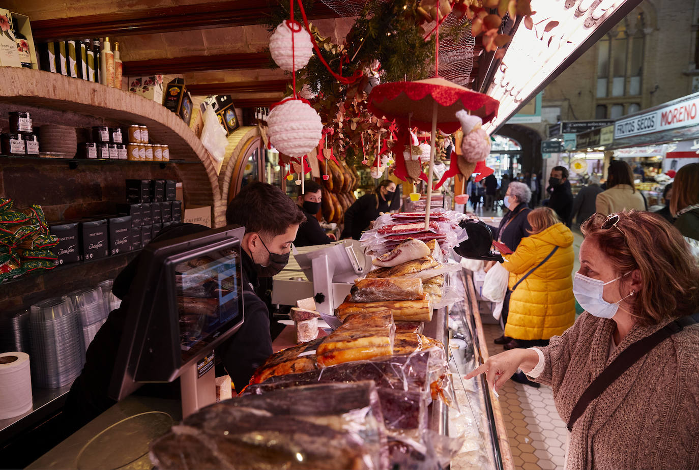 Con la Navidad a la vuelta de la esquina, los valencianos aprovechan para disfrutar del ambiente y realizar las compras en los mercados de la ciudad. La celebración de las fiestas navideñas este año será atípicas y con restricciones por la pandemia del coronavirus. En imagen, el Mercado Central de Valencia este martes.