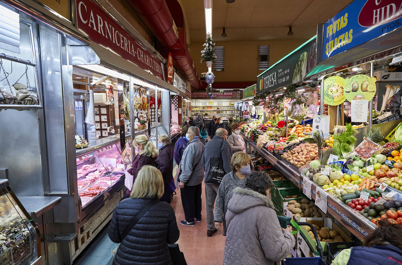 Con la Navidad a la vuelta de la esquina, los valencianos aprovechan para disfrutar del ambiente y realizar las compras en los mercados de la ciudad. La celebración de las fiestas navideñas este año será atípicas y con restricciones por la pandemia del coronavirus. En imagen, el Mercado del Cabaynal este martes.