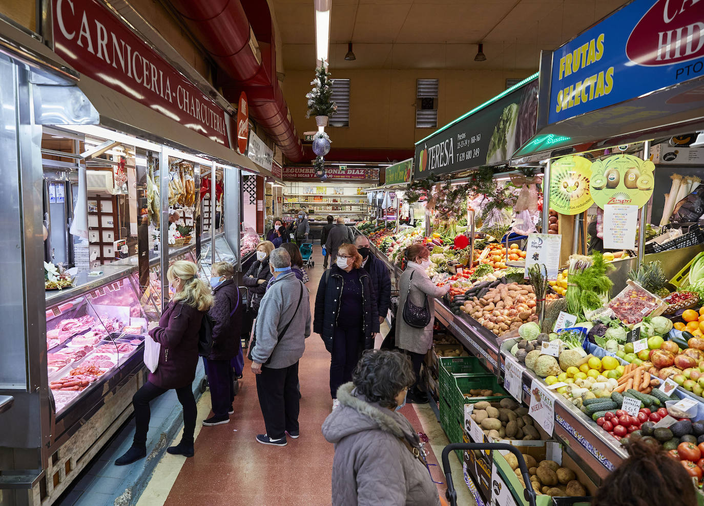 Con la Navidad a la vuelta de la esquina, los valencianos aprovechan para disfrutar del ambiente y realizar las compras en los mercados de la ciudad. La celebración de las fiestas navideñas este año será atípicas y con restricciones por la pandemia del coronavirus. En imagen, el Mercado del Cabaynal este martes.