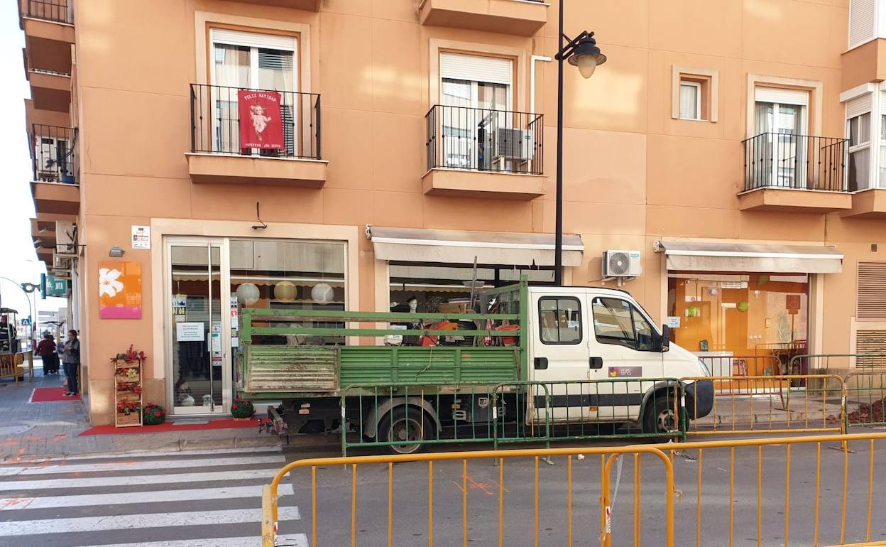 Un camión aparcado frente a uno de los comercios en la calle en obras. 