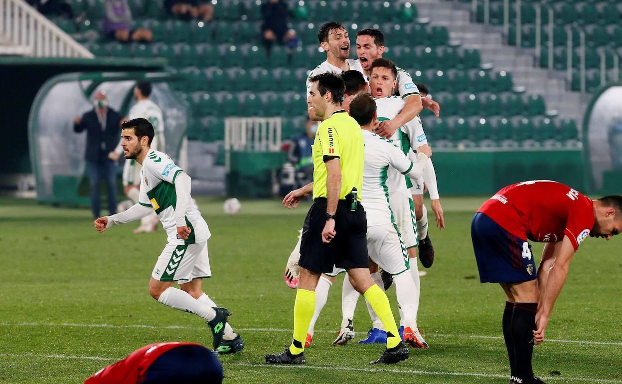 Los jugadores del Elche abrazan a Guido Carrillo tras anotar el tanto del empate ante Osasuna. 