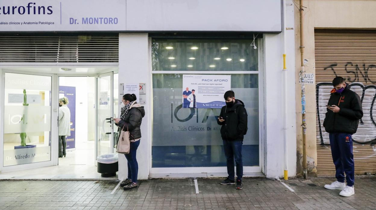 Tres personas esperan a la puerta de un laboratorio de Valencia que realiza pruebas PCR. irene marsilla